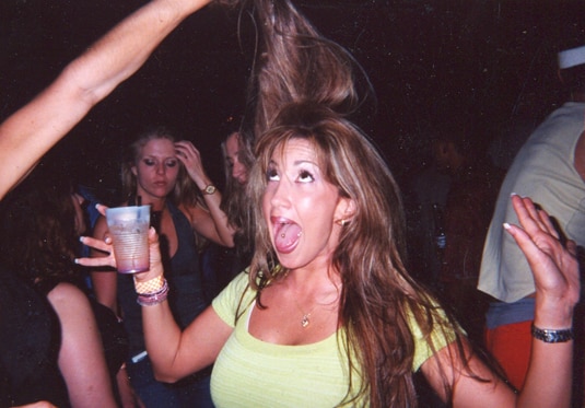 Jacqueline Laurita laughing at a party with a drink in her hand.