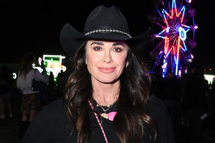 Kyle Richards smiling in all black at Neon Carnival.