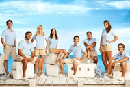 The cast of Below Deck Season 1 sit on a dock