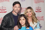 Denise Richards, Aaron Phypers, and Eloise Richards posing together in front of a step and repeat.