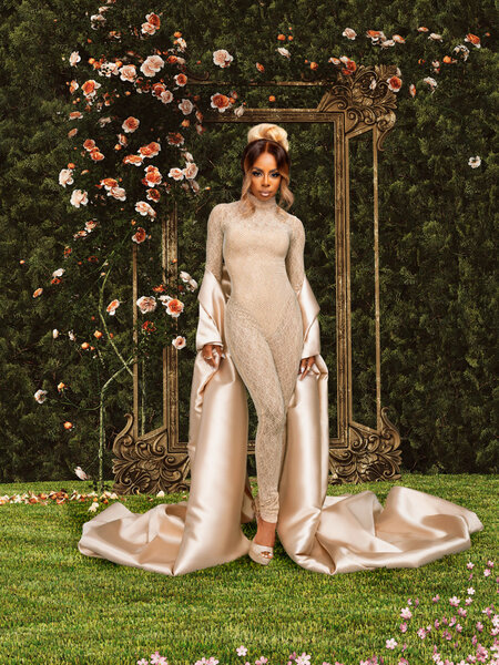 Candiace Dillard wearing a gold body suit and a long pink shawl in a garden.