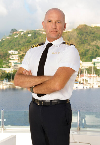 Captain Kerry Titheradge of Below Deck Season 11 wearing his uniform on a yacht.