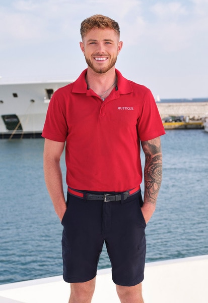 Nathan Gallager wearing his yachting uniform on a boat marina