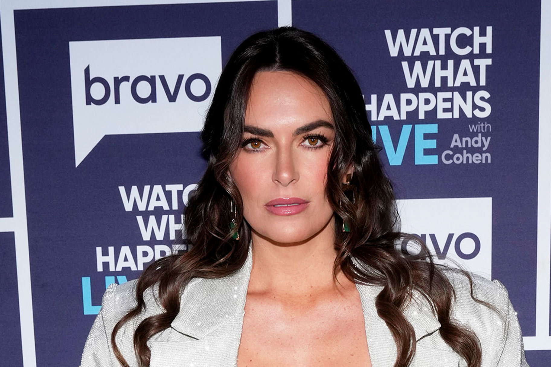 Katie Flood wearing a, crystal-embellished, 3 piece set in front of a step and repeat at the Watch What Happens Live clubhouse in New York City.