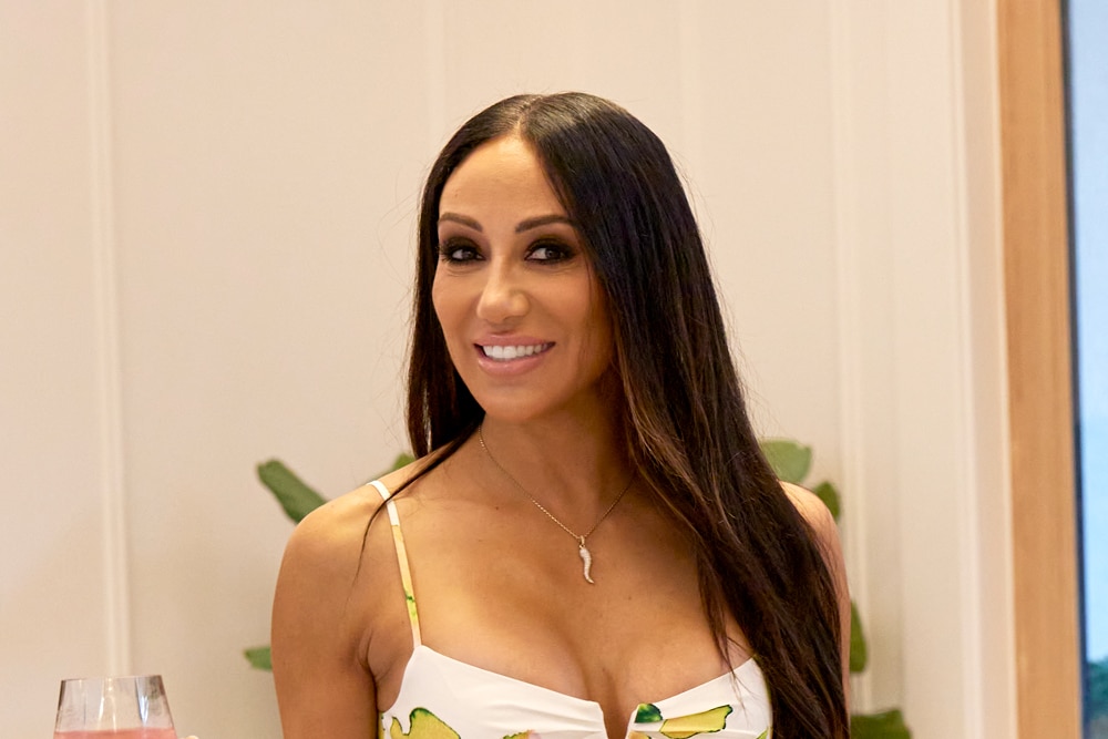 Melissa Gorga wearing a dress with lemons on it in her home.