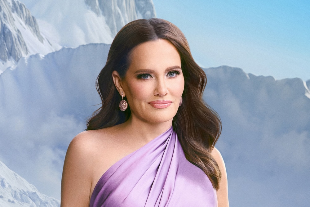 Meredith Marks wearing a purple gown and standy in front of a snowy mountain