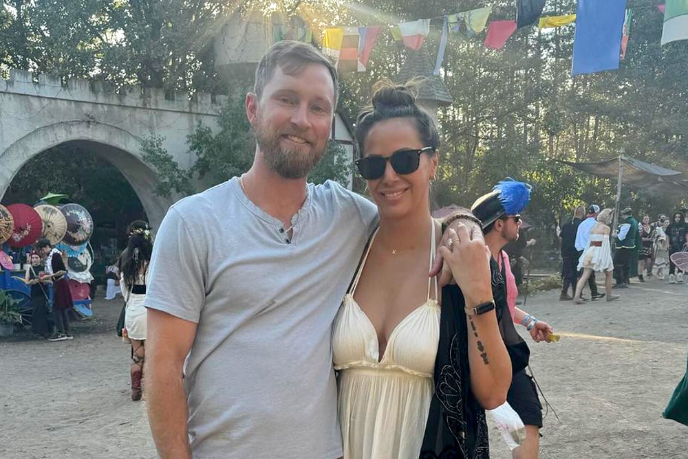 Kristen Doute and her fiance Luke Broderick standing outside at a festival together