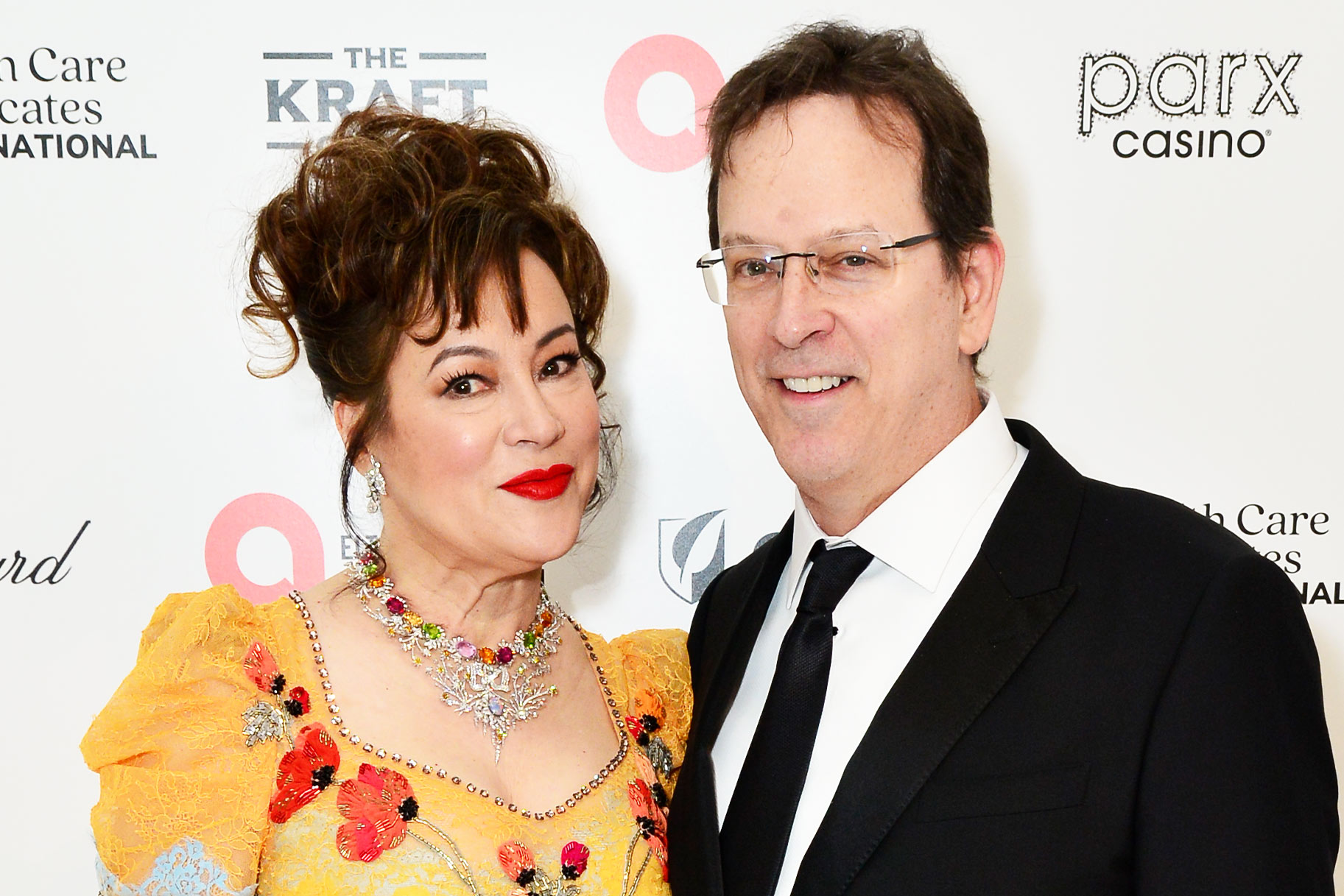 Jennifer Tilly and Phil Laak posing in front of a step and repeat.