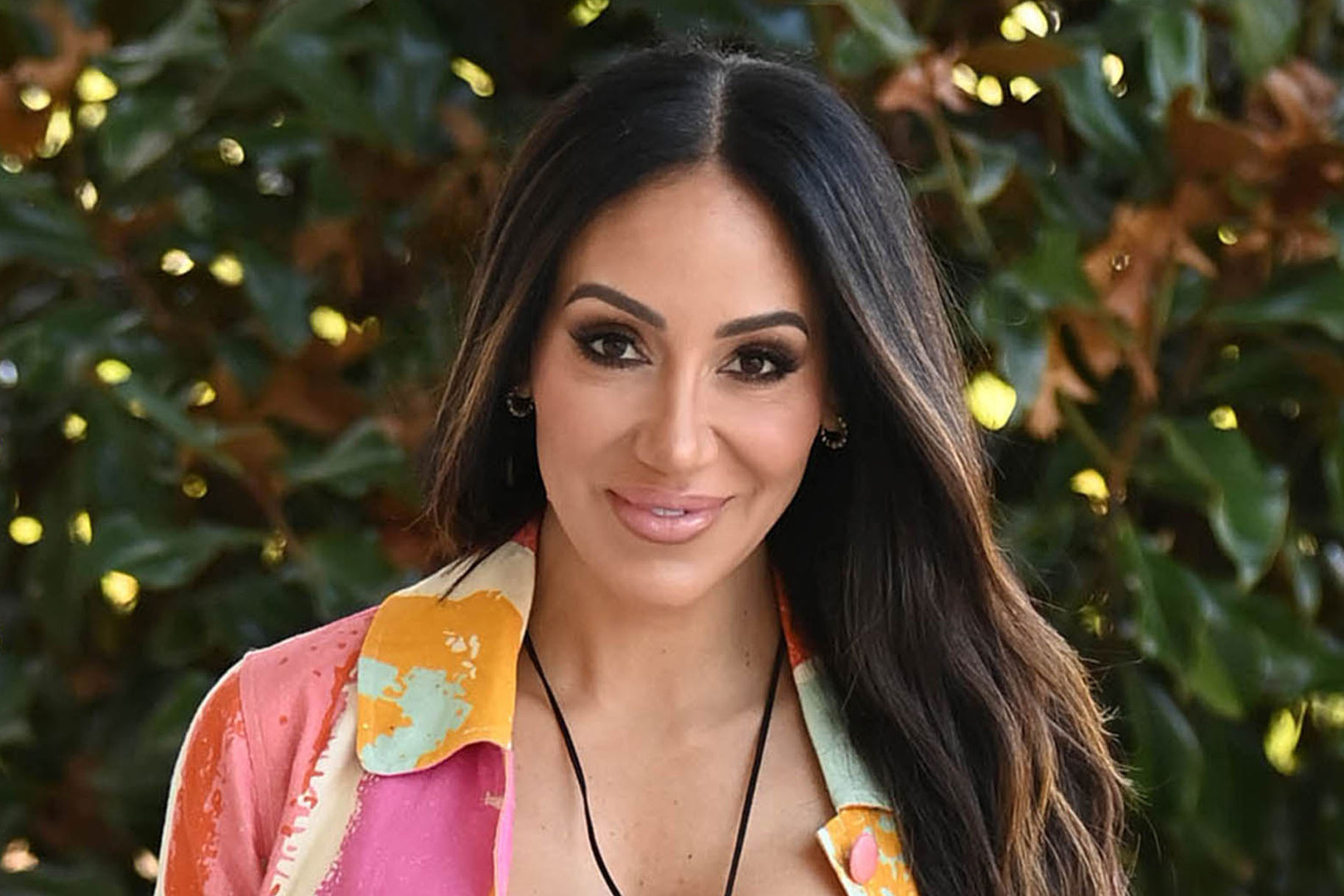 Melissa Gorga smiling outdoors in a colorful outfit.