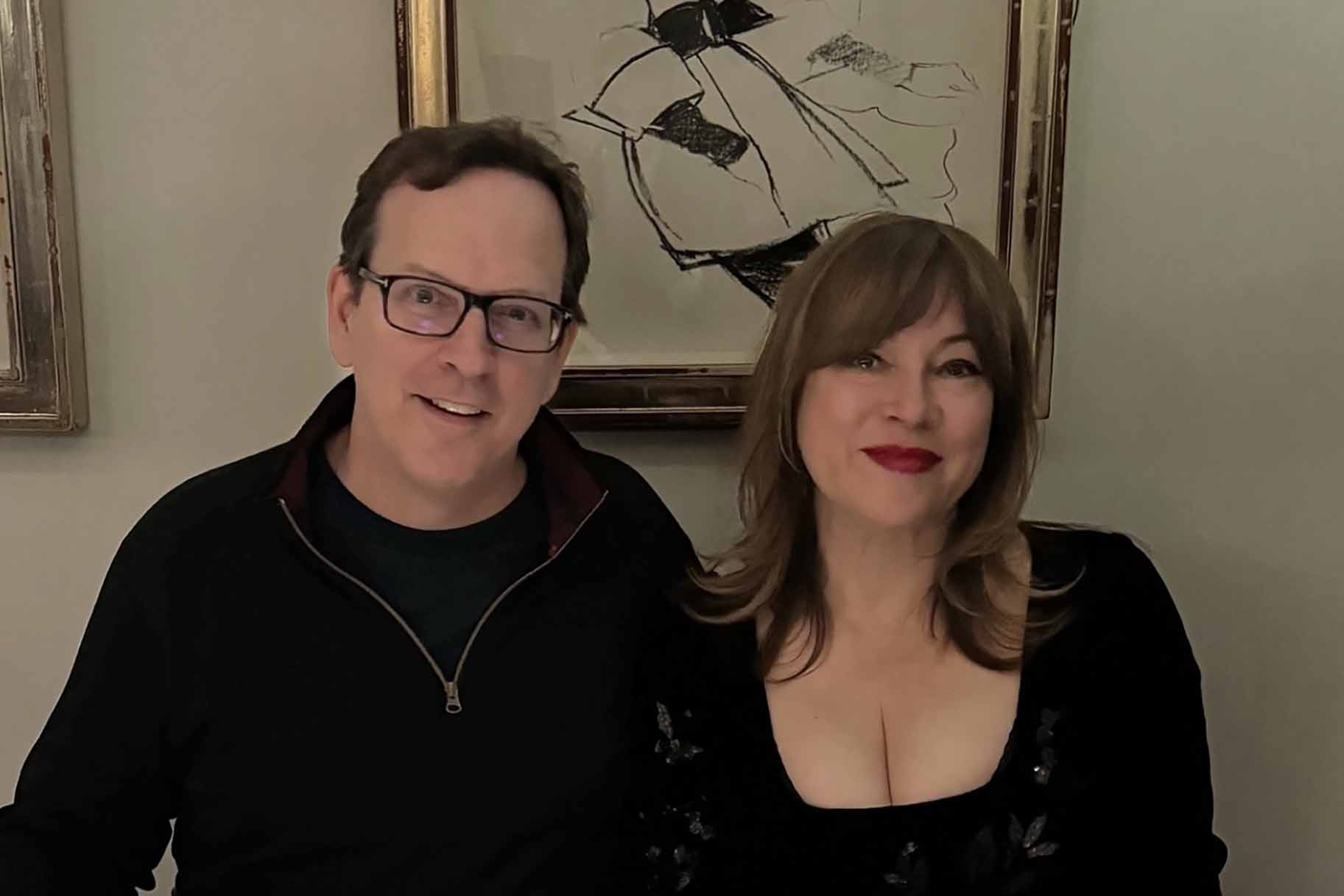 Jennifer Tilly and Phil Laak smile together in matching black outfits.