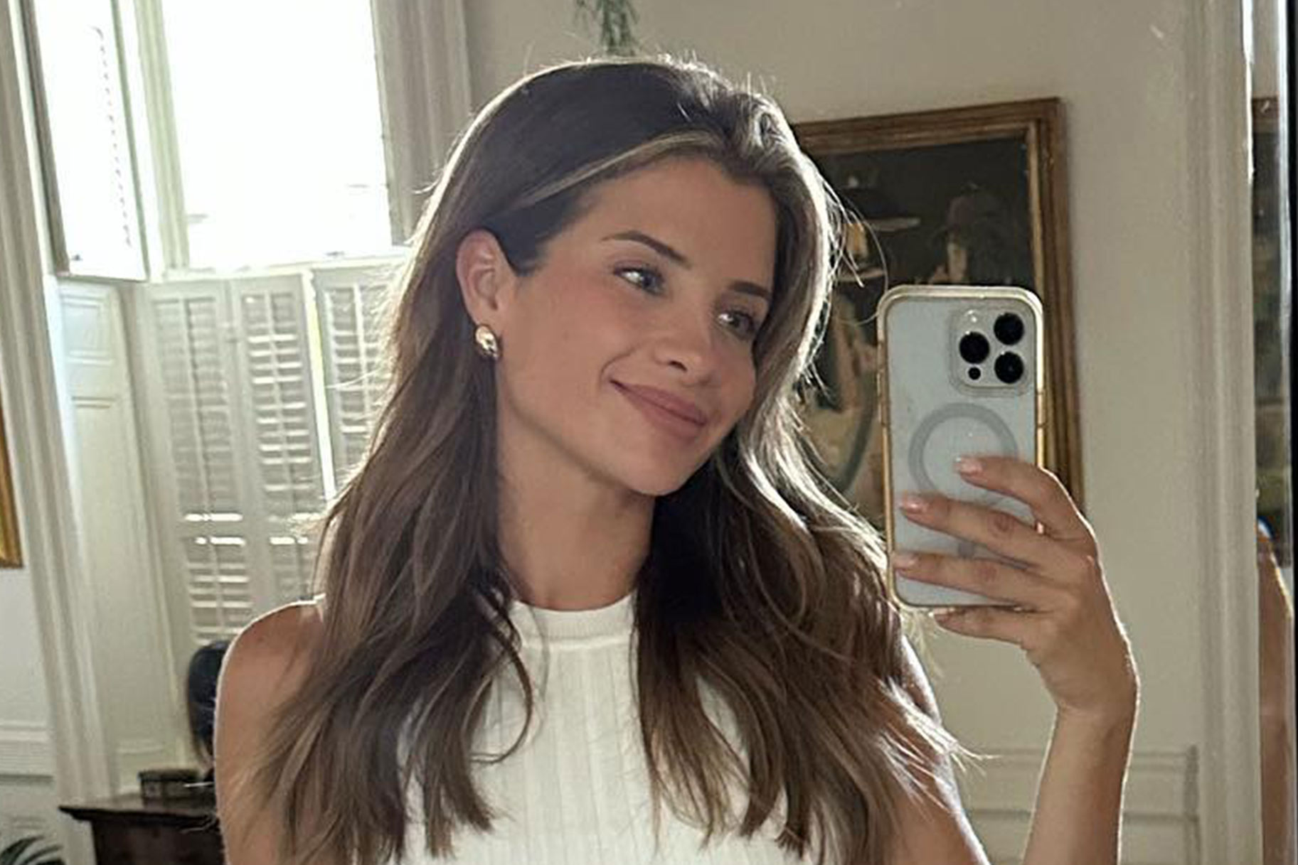 Naomie Olindo smiling and posing in a mirror.