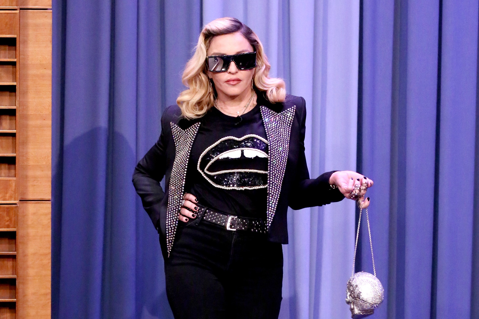 Madonna sits on Louis Vuitton luggage on budget flight