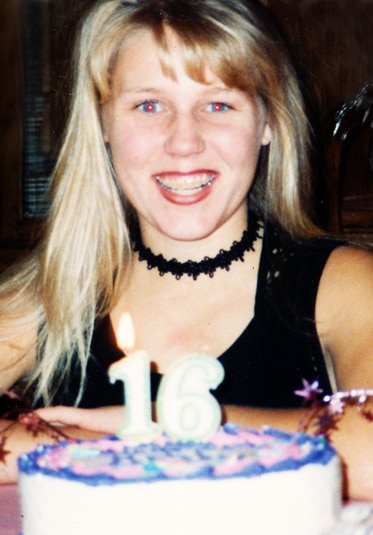 A teenage Gretchen Rossi holding a birthday cake with candles.