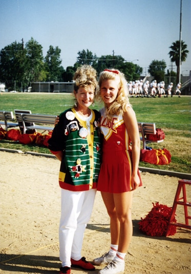 Gretchen Rossi standing next to her cheerleading coach in high school.