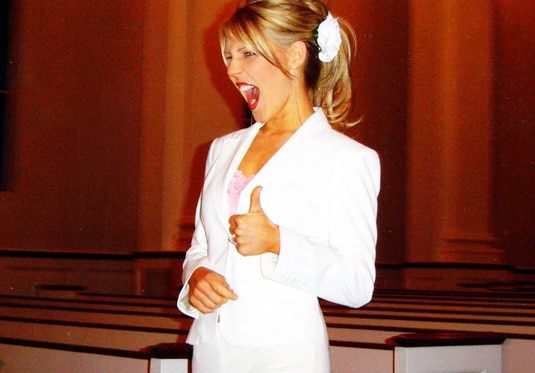 Gretchen Rossi giving a thumbs up in a white suit.