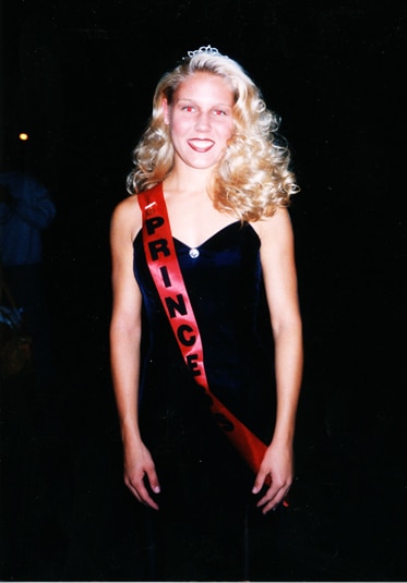 A young Gretchen Rossi wearing a black dress and a sash that says Princess.