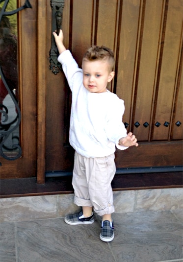 Jacqueline Laurita's son Nicholas as a child opening a wooden door wearing a white sweatshirt