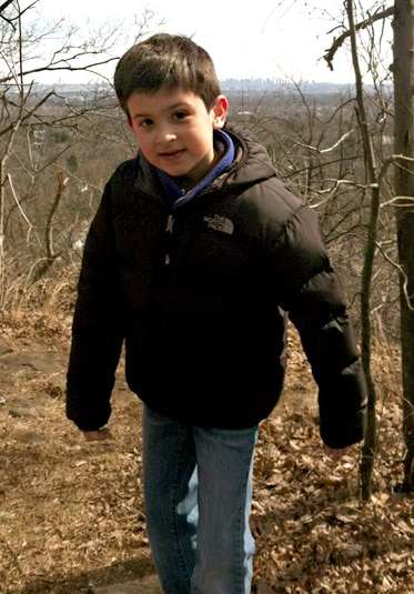 Jacqueline Laurita's son CJ as a child wearing a puffy coat in the woods