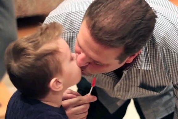Chris Laurita from the Real Housewives of New Jersey kissing his son Nicholas and holding a lollipop