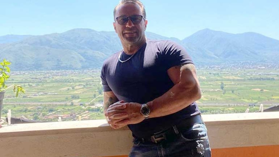 Joe Giudice smiling on a sunny day in front of mountains