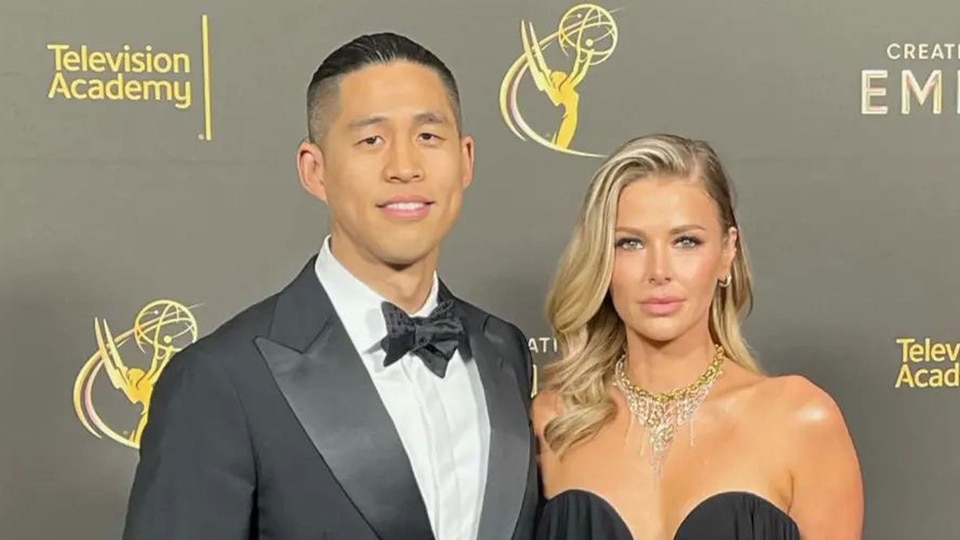 Ariana Madix and Daniel Wai posing together in front of a step and repeat.