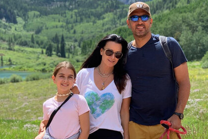 Kyle Richards Mauricio Umansky and Portia Umansky outside in the a field of grass together.