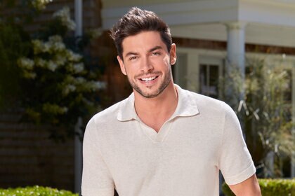 Andrea Denver smiling outdoors wearing a white polo.