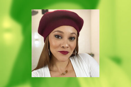 Ashley Darby in a selfie wearing a burgundy colored beret and red lipstick.