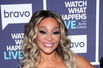 Karen Huger smiling in front of the Watch What Happens Live step and repeat.