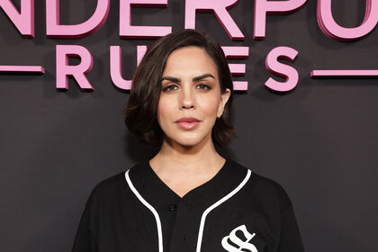 Katie Maloney in front of a Vanderpump Rules step and repeat.