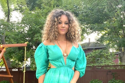 Ashley Darby wearing a green dress and posing for a photo.