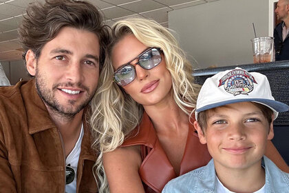 Madison LeCroy, Brett Randle, and Hudson Hughes smiling together at a racetrack.