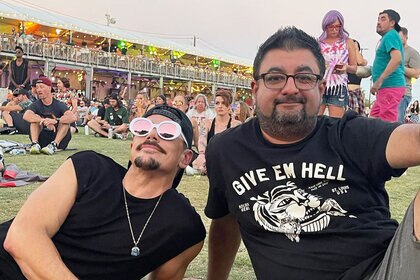 Tom Sandoval and Ali Rafiq sitting together at a concert.