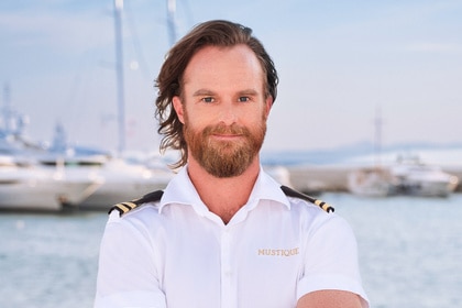 Iain MacLean wearing his yachting uniform on a boat marina