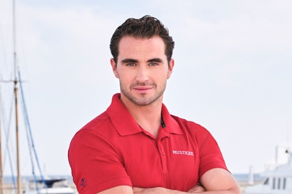 Joe Bradley wearing a red polo on a boat marina