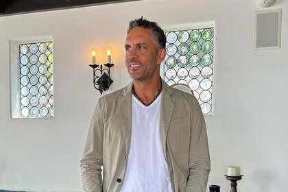 Mauricio Umansky wearing a beige jacket and white tee in a livingroom.