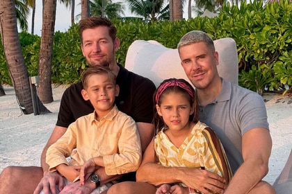 Fredrik Eklund on a beach with his husband and two young children.