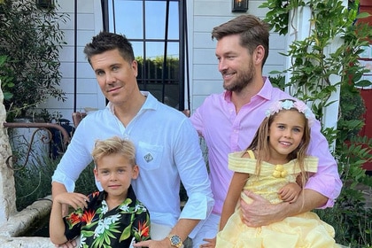 Fredrik Eklund, with his husband, and two children in front of their house.