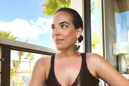 Danielle Olivera wearing a black top on a balcony.