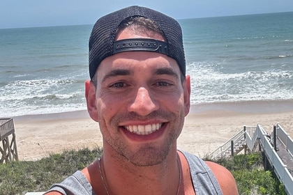 Jesse Solomon smiling in front of a beach.