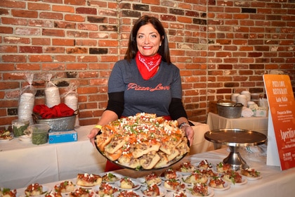 Kathy Wakile smiling and holding a large plate of food.
