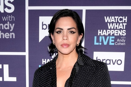 Katie Maloney standing in front of a step and repeat.