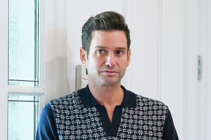 Josh Flagg wearing a collared shirt in the foyer of a home