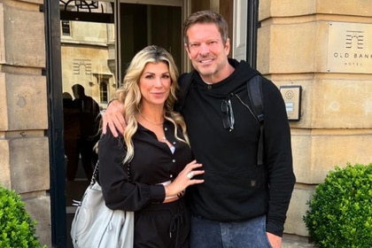 Alexis Bellino and John Janssen pose together outside of a hotel