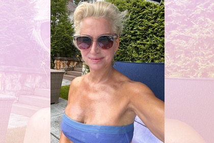 Dorinda Medley wearing a blue bathing suit and sunglasses in her backyard