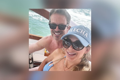 Alexis Bellino and John Janssen smiling together on a boat.