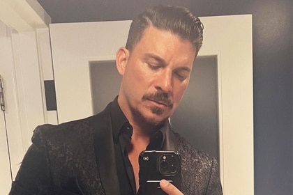 Jax Taylor posing in a suit in a mirror.