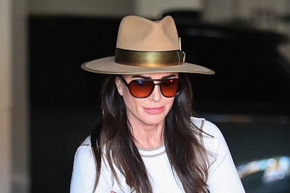 Kyle Richards wearing a wide brim hat and a white tee while out in LA