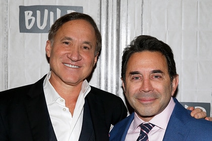 Dr. Terry Dubrow and Dr. Paul Nassif smiling next to each other.