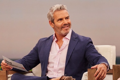 Andy Cohen smiling and sitting on set at The Real Housewives of Orange County Season 17 Reunion.